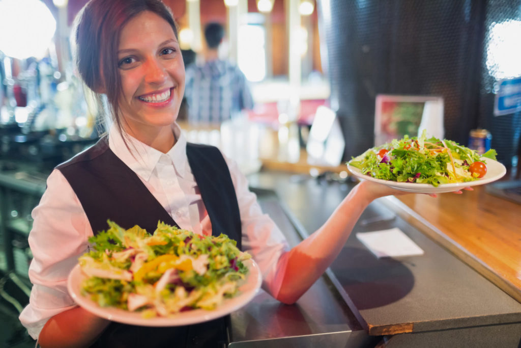 server holding plates of salads