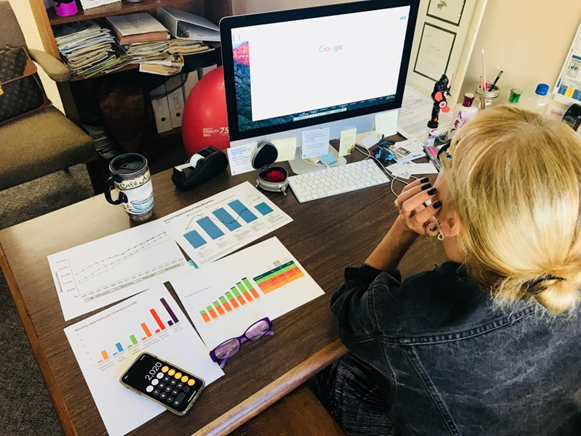 Overhead shot of woman using computer, working on business plan.