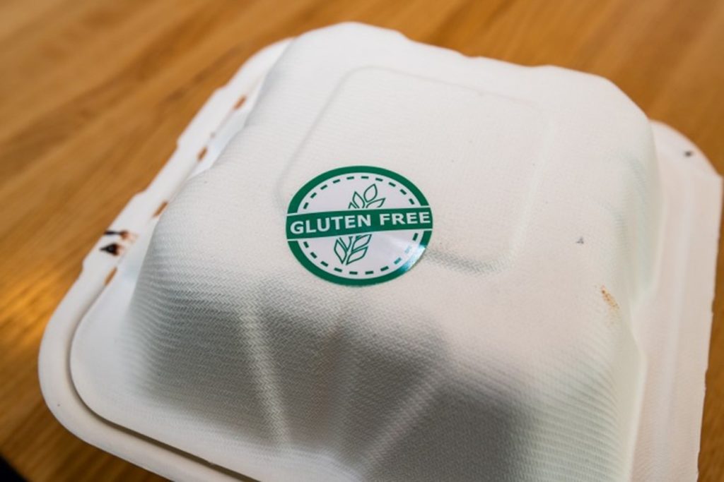 Paper takeout box with a “gluten free” sticker on the lid.