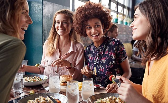 Four Friends around a table laughing and having a good time