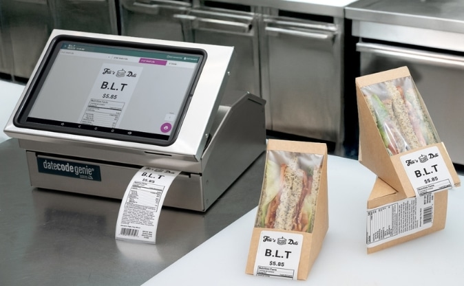 DateCodeGenie automated food labeling system printing nutrition labels for packaged sandwiches in a cafeteria kitchen
