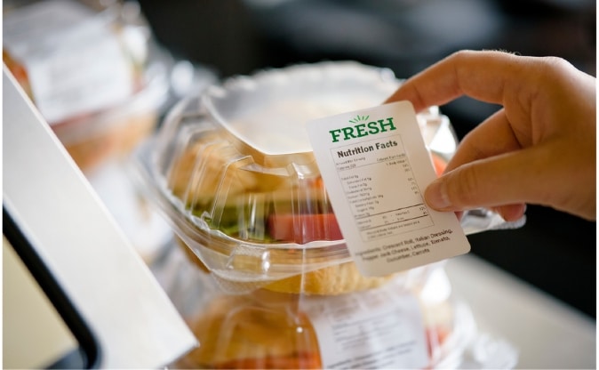 Nutrition and allergen label being applied to packaged food for managed dining services
